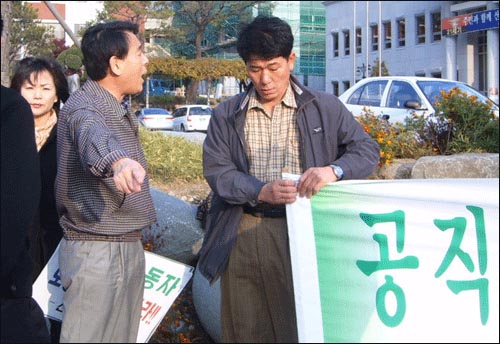 산청민중연대가 공무원노조 총파업과 관련한 집회를 하지 못하도록 이평식 산청부군수(좌)가 현수막을 들고 있는 조진호 집행위원장에게 거세게 항의하며 방해하고 있다. 